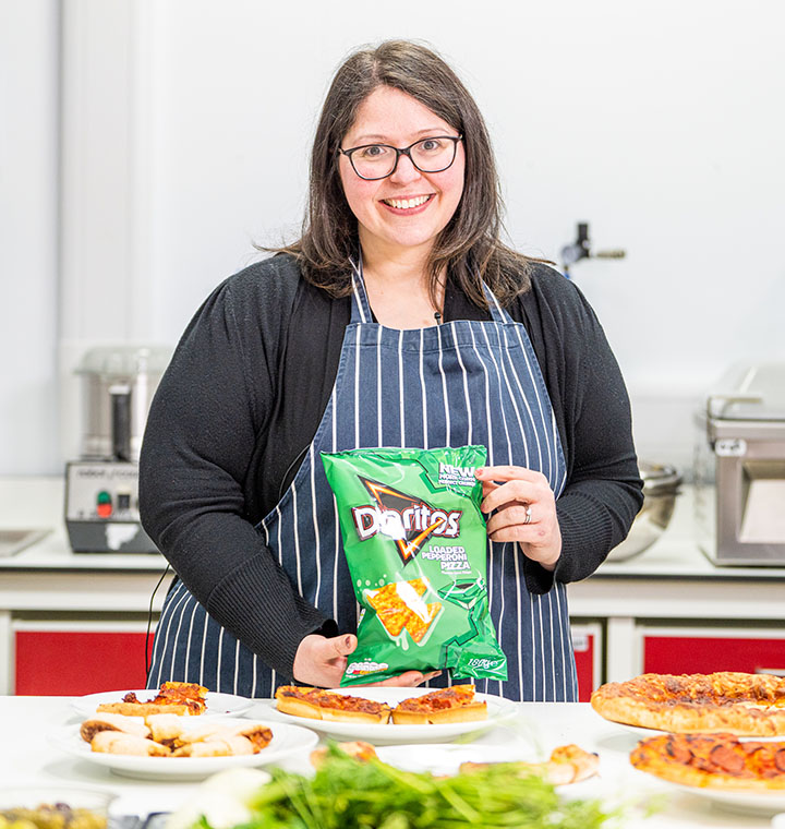 Woman holding Doritos Loaded Pepperoni Pizza bag